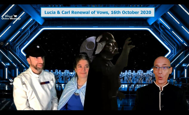 Virtual Celebrant performing ceremony for white couple with Star Wars movie theme on the hangar deck of a Starship Destroyer. Darth Vader has just entered the scene.